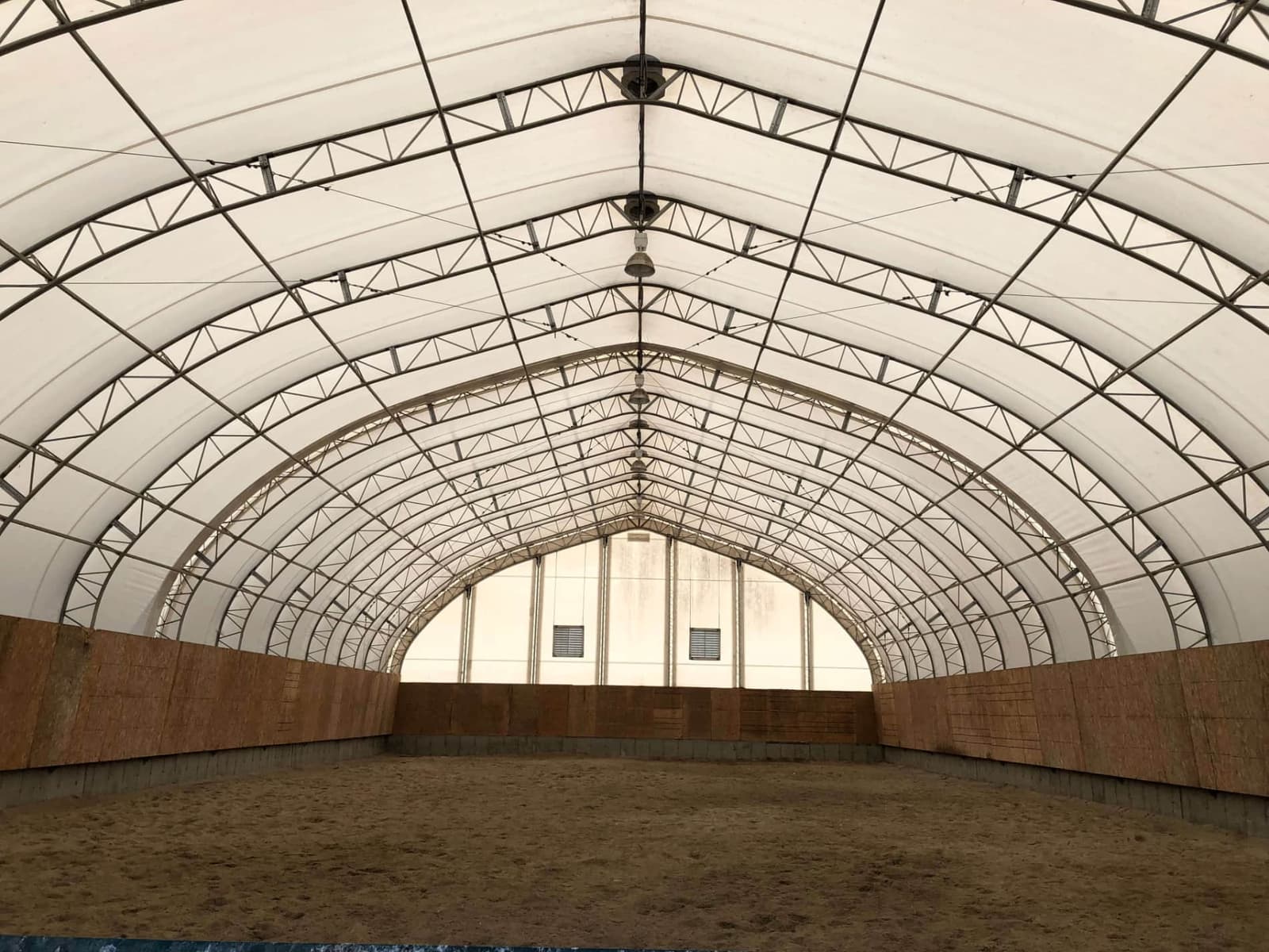 Intérieur du manège de type Dôme, avec sol de sable et bandes de bois